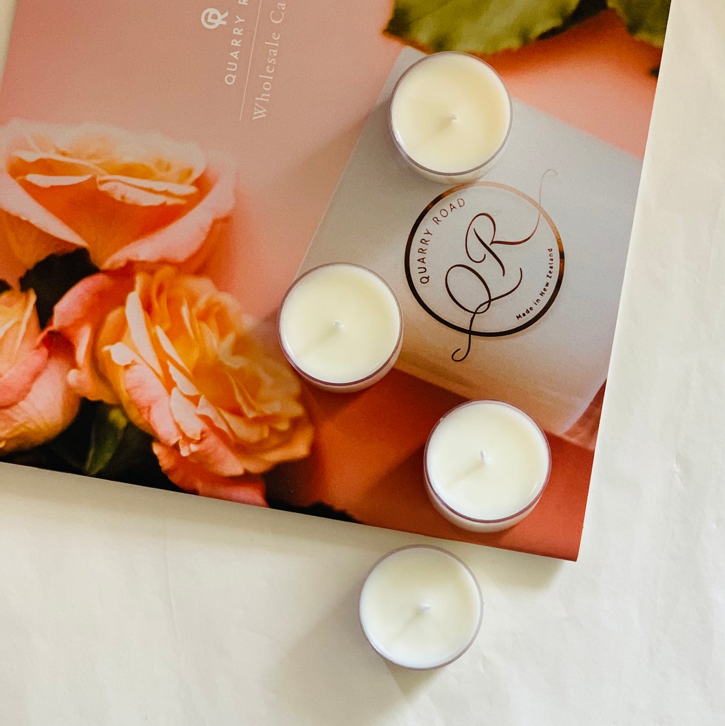 Quarry Road tea light candles sitting on a Quarry Road catalogue of wholesale candle prices. Delicious fragrances available to match our pure soy candles .
