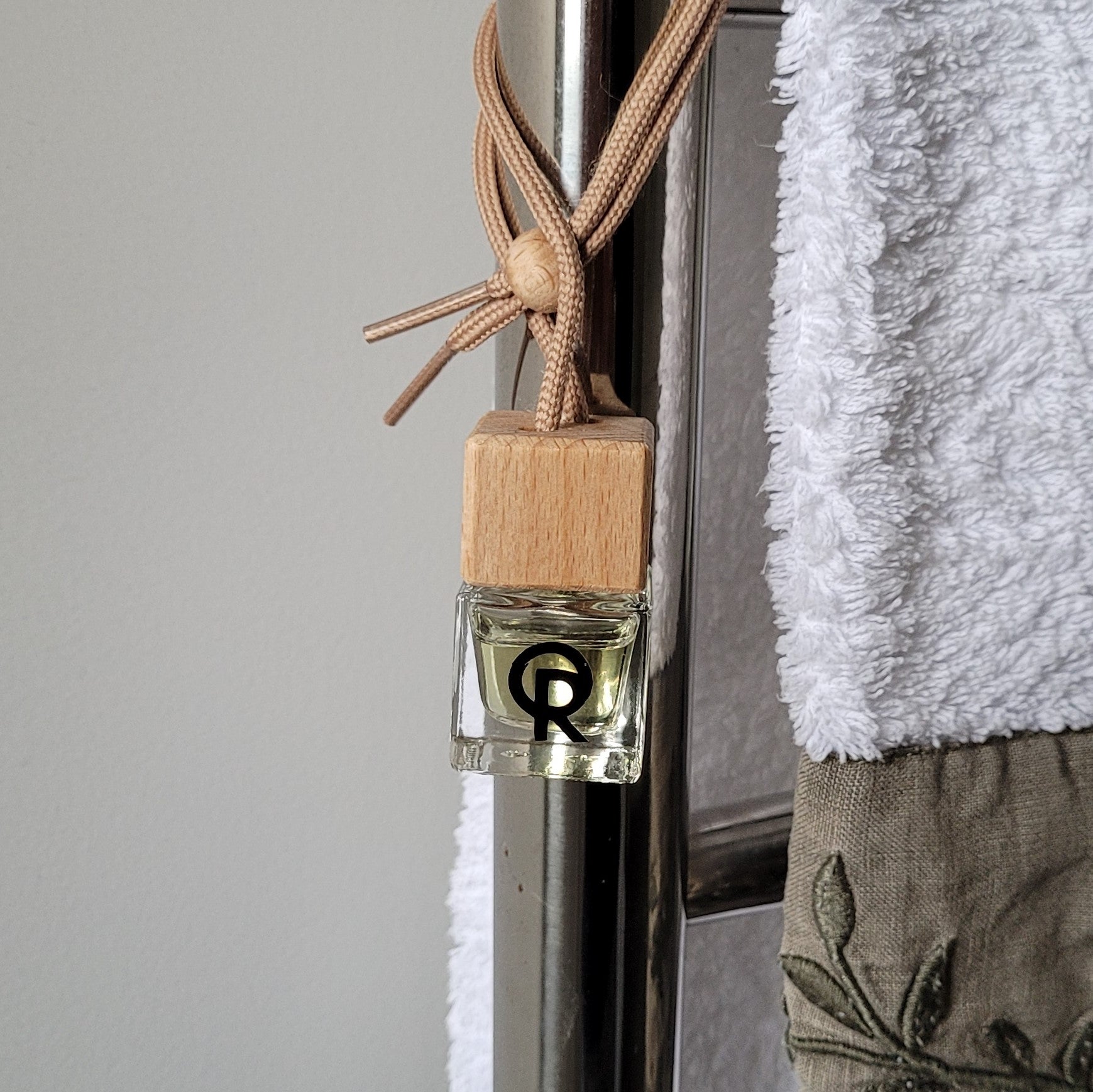 Small air diffuser made by Quarry Road tied to towel rail in bathroom.